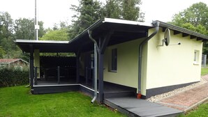 Un bâtiment d’un seul étage, doté d’un espace extérieur couvert et d’une petite fenêtre.