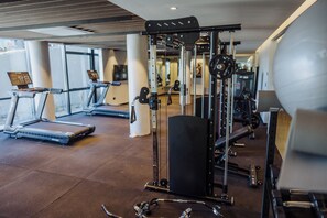 Ein Fitnessstudio mit Laufbändern, Kraftgeräten und einem großen Trainingsball.