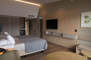 Ein modernes Hotelzimmer mit Bett, Nachttisch und einem an der Wand befestigten Flachbildfernseher.