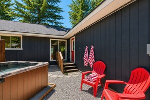 A hot tub, outdoor seating, and a covered entrance to a building. - Retro | Hot Tub | Dogs OK | Community Beach | BBQ (Leavenworth)