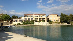 Un grande edificio a più piani con un cortile interno e uno specchio d'acqua di fronte.