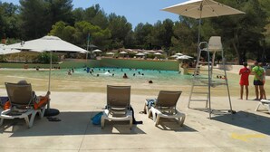Area piscina con lettini e ombrelloni.