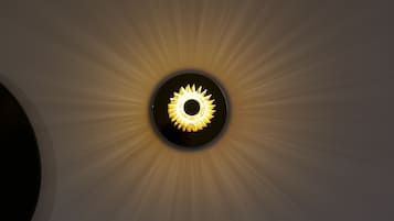 Un luminaire de plafond circulaire, dont le design évoque un soleil.