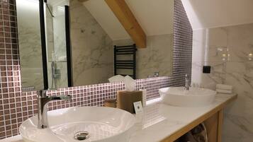 A bathroom with two sinks, a mirror, and a towel rack.