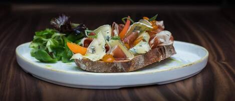 A plate with a sandwich and a side salad on a white plate.