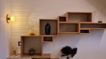 A wall with a wooden shelf unit containing various decorative items.