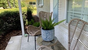 Eine Terrasse mit Korbstühlen und einem Topfpflanzen.
