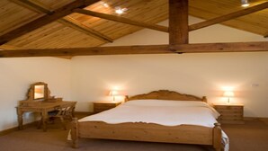 Camera da letto con struttura in legno, un letto, comodini, una sedia e uno specchio.
