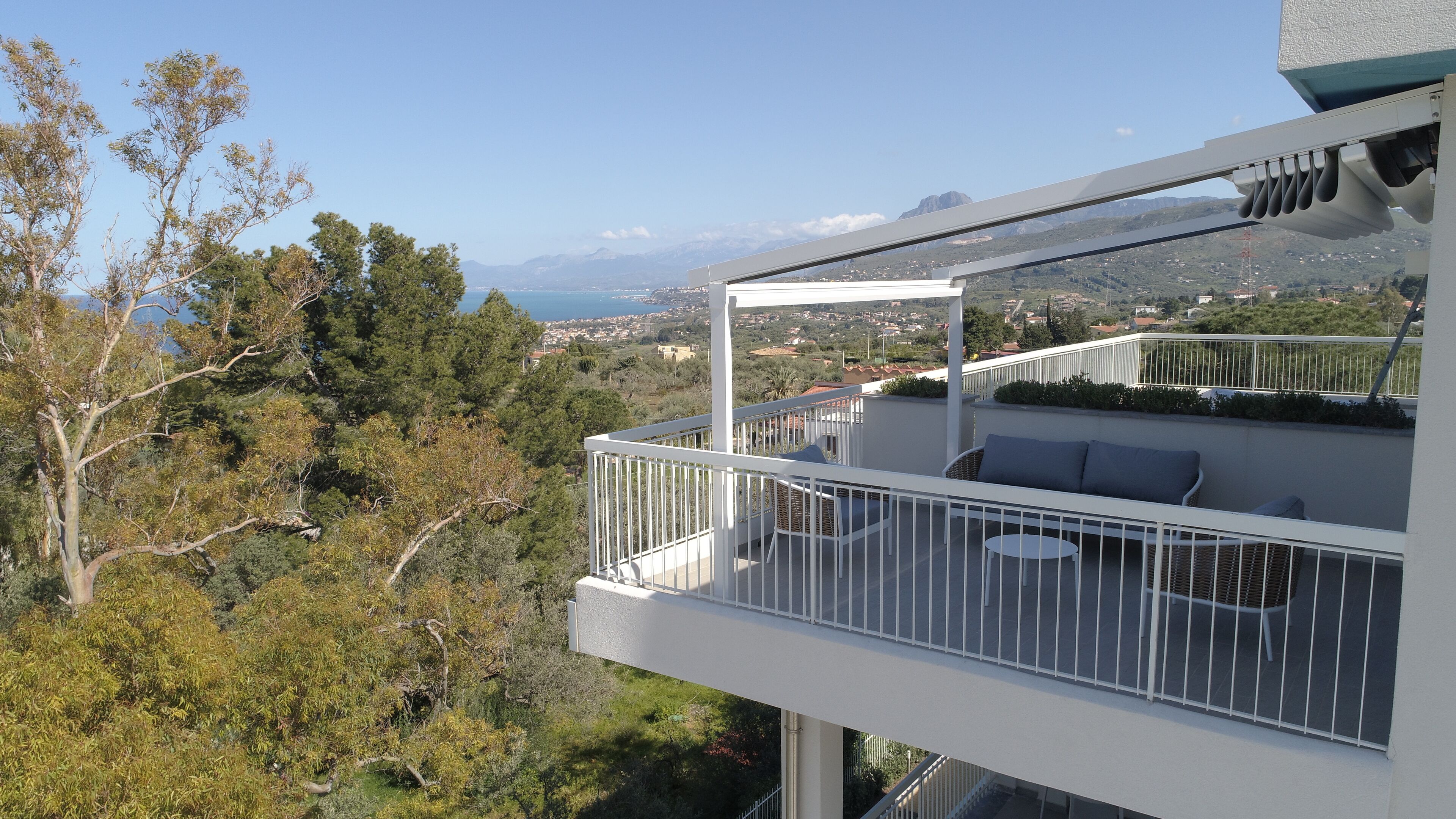 Un balcon avec une balustrade blanche, une petite table et une chaise.