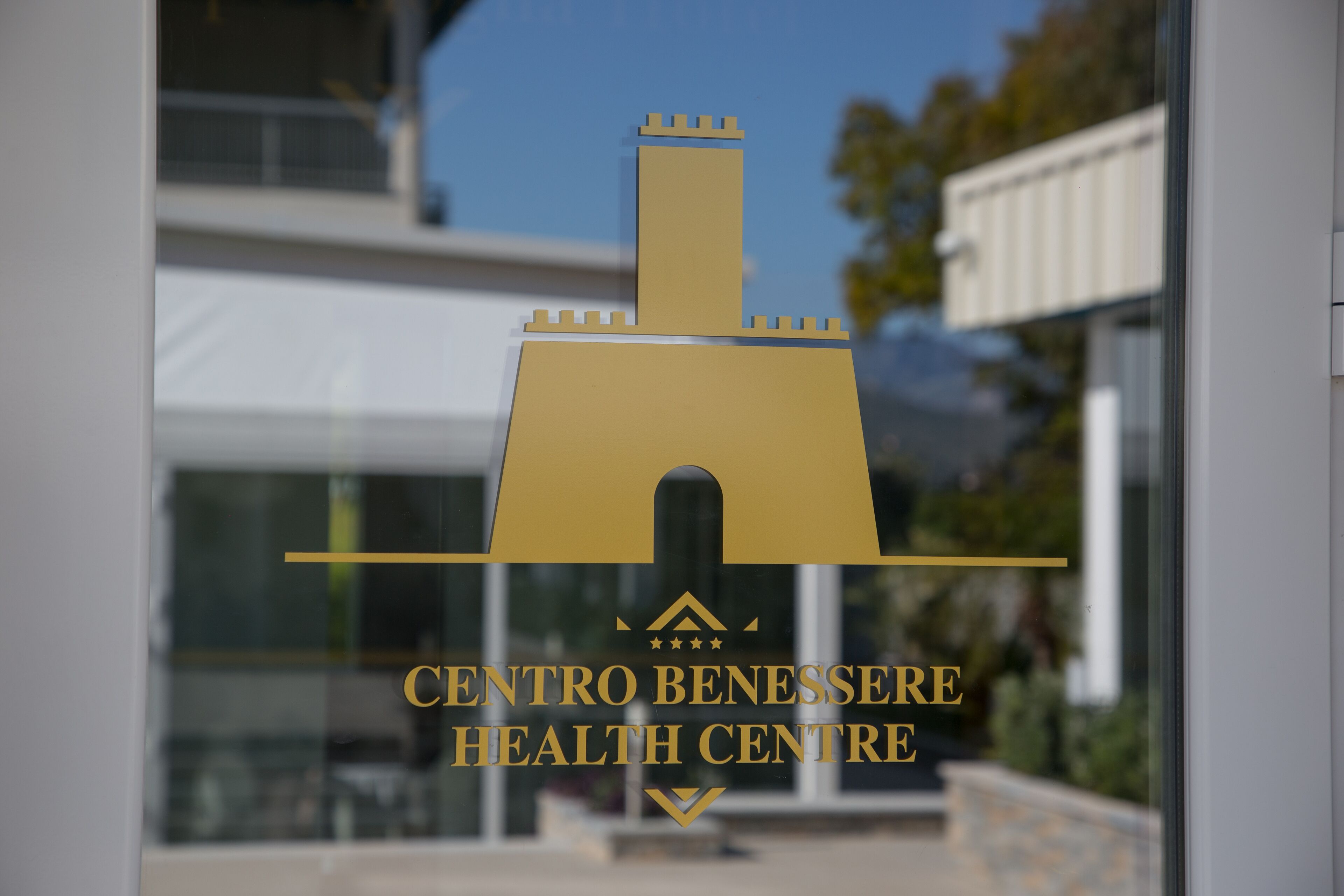 A logo of Centro Benessere Health Centre on a glass window.