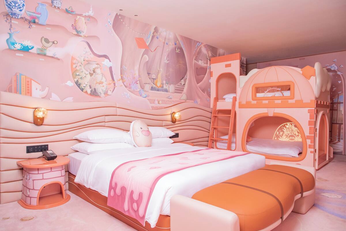 A children's room with a bed, a playhouse, and a mural on the wall.