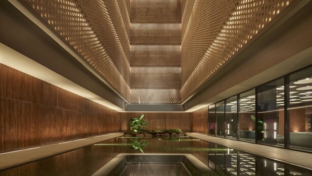 A modern interior with a reflective water feature, wooden panel walls, and a patterned ceiling.