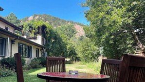 Ein runder Tisch mit vier Holzstühlen in einem Garten.