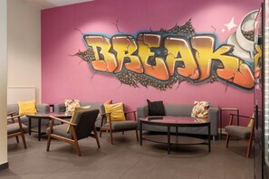 A modern lounge area with sofas, armchairs, and a coffee table. - Neuchatel City Hotel (Neuchatel)