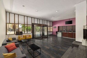 A modern lobby with a reception desk, seating area, and large windows. - Neuchatel City Hotel (Neuchatel)
