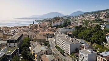 A cityscape with a mix of historic and modern buildings, a prominent church, and a view of the sea.