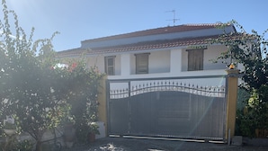 A house with a gated driveway and a gravel path leading to the entrance. - Cottage located along the coastal strip opposite Asinara. (Eden Beach)