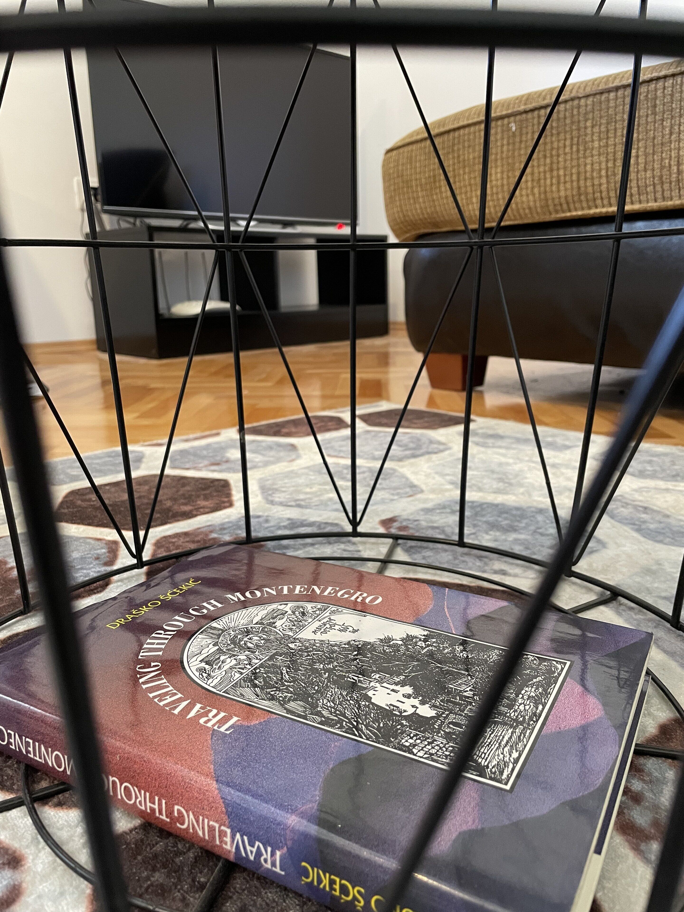 Un libro titulado 'Drasko a través de Montenegro' sobre una mesa con mantel estampado.