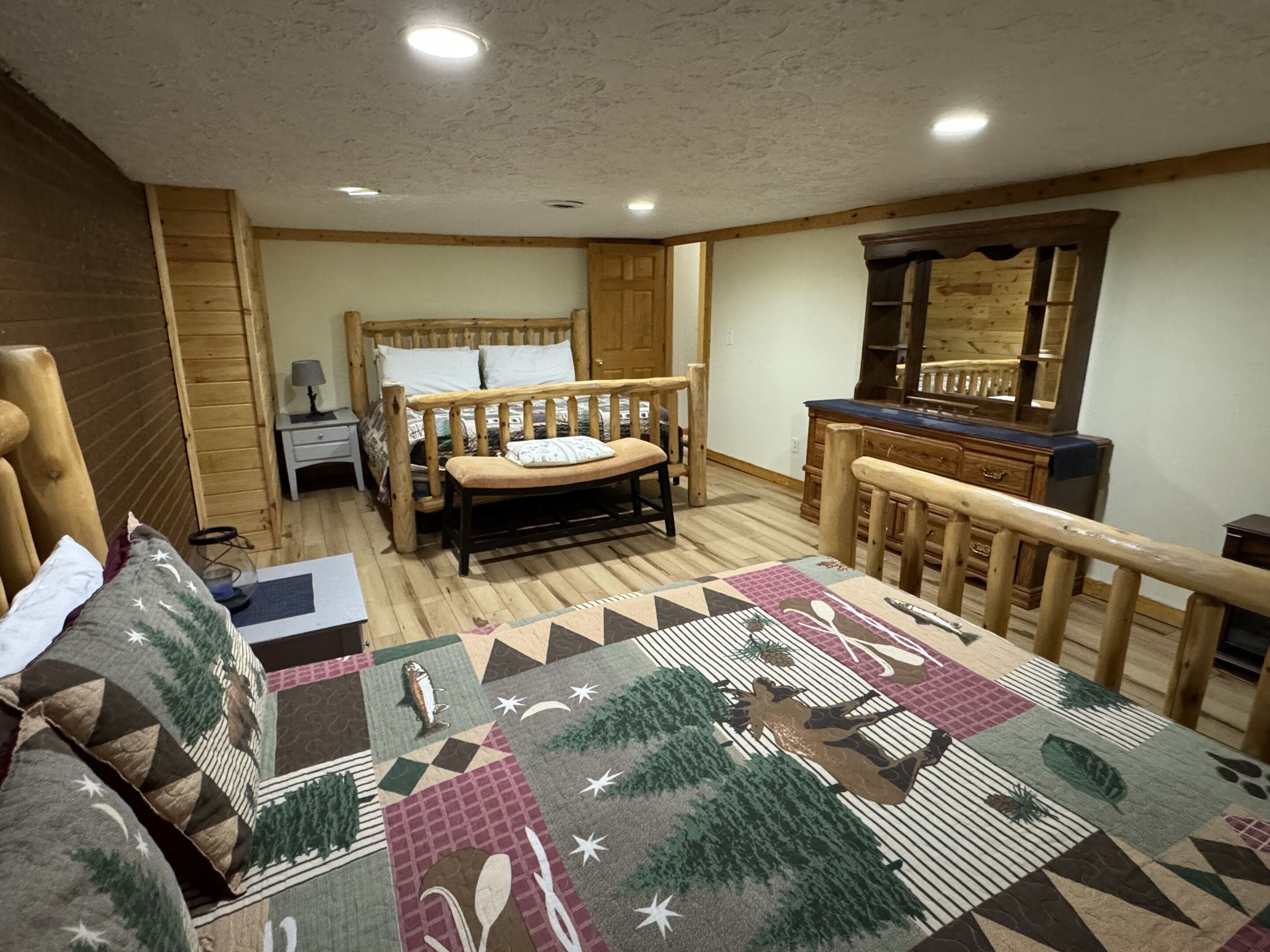 Une chambre confortable avec un lit en bois, une table de chevet, une commode et un miroir.