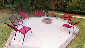 An outdoor seating area with red chairs and a fire pit. - Secluded Luxury Lodge 57 acres Hocking Hills Ohio (Logan)