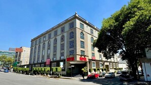 Um edifício grande e histórico com vários sinais indicando 'HOTEL'.