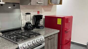 Kylskåp, mikrovågsugn, spishäll och grytor/köksredskap