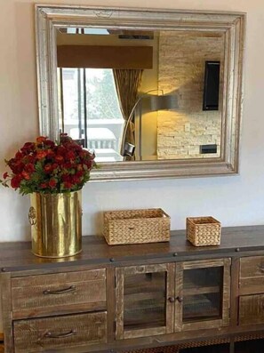 A wooden dresser with a mirror above it, a vase of red flowers, and two woven baskets. - Beautiful view by the creek, close to Vail Village (Vail)