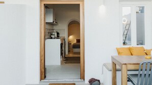 Een modern interieur met een keuken, een eethoek en een trap naar een hoger niveau.