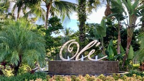 Un jardín con un gran letrero decorativo que dice 'Ole' en el centro.