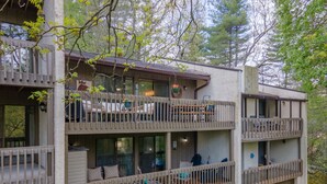 Un chalet à plusieurs étages doté de balcons, d’un espace extérieur aménagé et d’un style rustique.