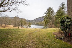 A grassy area with a lake, trees, and a building in the background. - Lake Fairfield Hideaway (Sapphire)