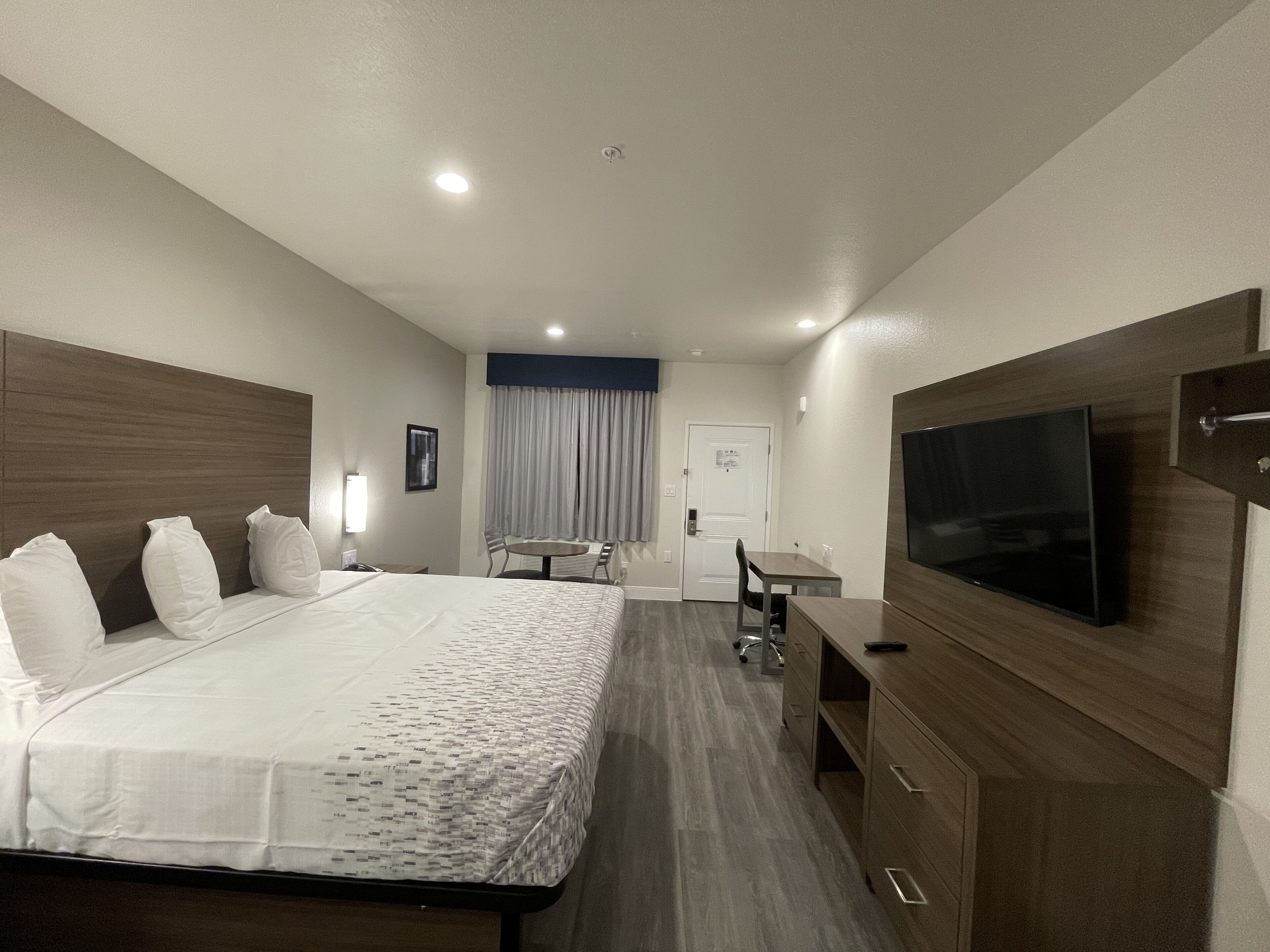 Escritorio, cortinas blackout y tabla de planchar con plancha 