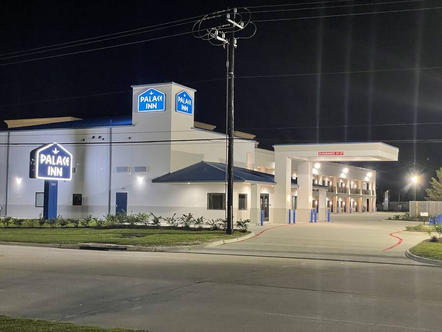 A hotel with a prominent sign reading "Palace Inn" and a gas station attached to it.