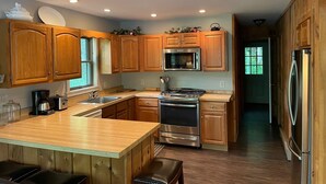 Une cuisine moderne avec des meubles en bois, des appareils en acier inoxydable et un grand îlot central.