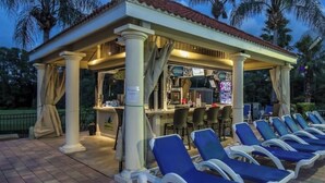 Un espace extérieur aménagé, abrité et doté de fauteuils confortables et d’un bar.