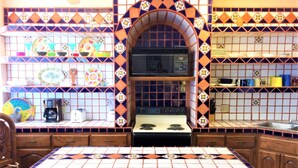 A kitchen with a central island, wooden cabinets, and a tiled backsplash.