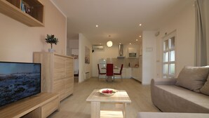 A modern living room with a flat-screen TV, a wooden coffee table, and a beige sofa. - Vacation apartment Bungalow Melisa 5 with pool (POREC)