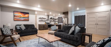 A modern living room with two sofas, a coffee table, and a dining area.