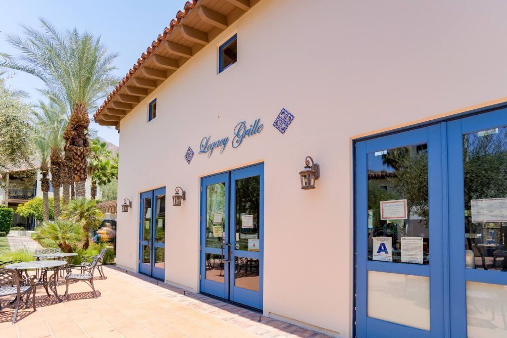 A building with a sign reading "Legacy Grille" and large blue-framed windows.