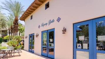 A building with a sign reading "Legacy Grille" and large blue-framed windows.