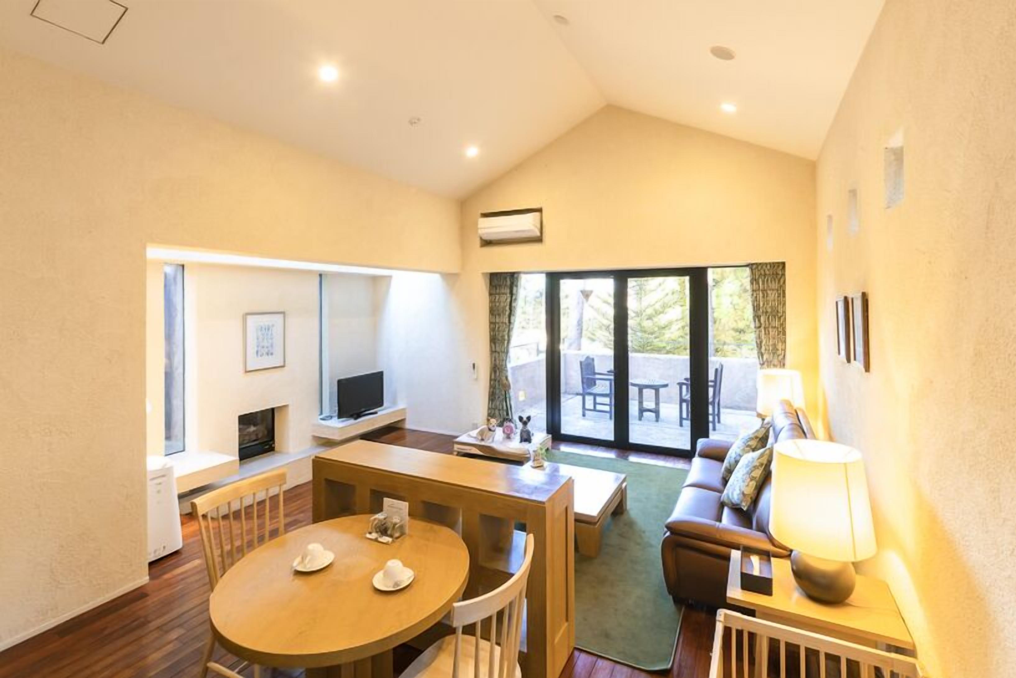 Amplia sala de estar con mesa de comedor, sofá y televisor.