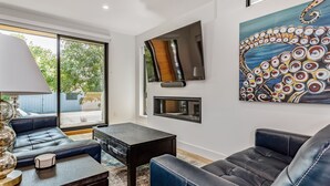 Un salon moderne avec un canapé, une table basse et un tableau accroché au mur.