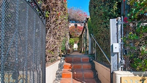 A narrow stone staircase leading to a gate with the number 2282, surrounded by greenery and a metal fence. - Air Concierge Old Town Charming Cottages 1 (San Diego)