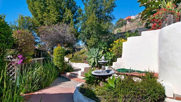 A garden pathway with a fountain, surrounded by various plants and trees. - Air Concierge Old Town Charming Cottages 1 (San Diego)