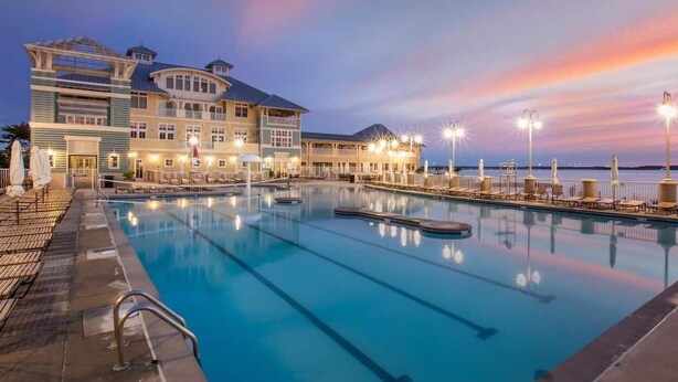 A large hotel with a swimming pool, multiple decks, and outdoor lighting. - SUNSET ISLAND Spacious 5-BR - TONS of Amenities (Ocean City)