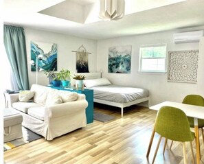 Relax in this stylish room with a single bed, sofa, and dining table, surrounded by beautiful views of the outdoors.
