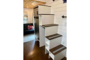 A compact kitchen with white cabinetry and a built-in refrigerator.