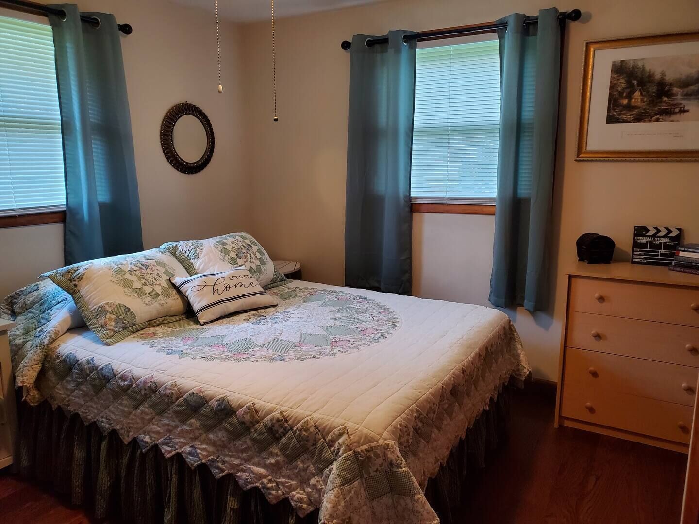 Une chambre à coucher avec un lit, une commode et un tableau encadré au mur.