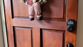 Une porte en bois ornée d’une pancarte de bienvenue et d’une figurine décorative.