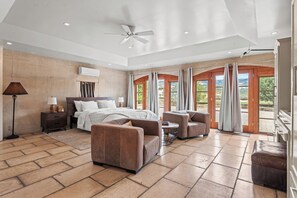 A spacious bedroom with a large bed, two sofas, a coffee table, and a ceiling fan. - Entire villa in Hopland, California (Hopland)